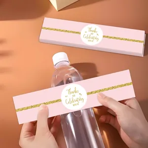 Dettaglio di etichette rosa per bottiglie d'acqua con glitter dorati per matrimoni