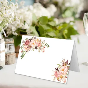 Détail d'un marque-place plié avec fleurs à l'aquarelle pour mariages et fêtes