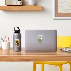 Retro cat tarot stickers displayed on a laptop and water bottle in a lifestyle setting