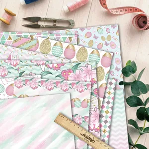 Flat lay of Easter bunny and floral scrapbook papers with DIY crafting tools on wood