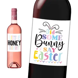 Close-up of Easter wine bottle stickers with bunny ears and pastel artistic typography
