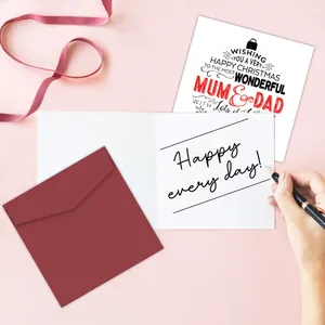 Biglietto di Natale per mamma e papà con busta rossa e nastro su sfondo rosa