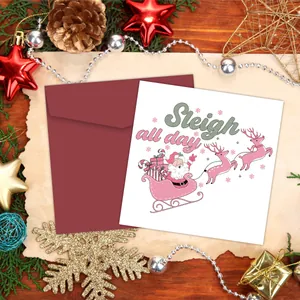 Nahaufnahme der Weihnachtskarte Sleigh All Day mit rotem Umschlag auf festlichem Holz