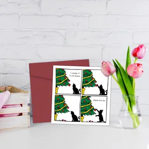 Divertente biglietto di Natale con gatto nero e busta rossa su sfondo di mattoni