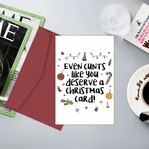 Flat lay of humorous Christmas card with festive hand-drawn icons and red envelope
