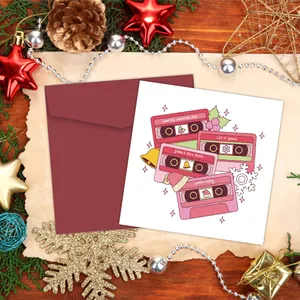 Nahaufnahme einer Weihnachtskarte mit Retro-Kassetten und passendem dunkelrotem Umschlag