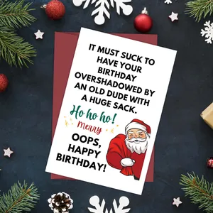 Folded Christmas greeting card with humor quote and red envelope on festive desk