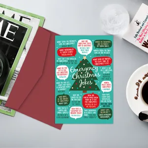 Vue à plat d'une carte de blagues de Noël avec enveloppe rouge sur un bureau cosy