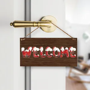 Wooden Christmas Welcome sign with Santa motifs hanging on a gold door handle
