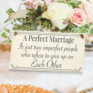 Detail of wooden wedding plaque with marriage quote among elegant floral decorations