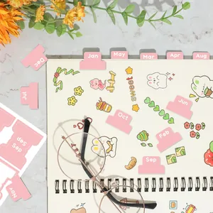Détail d'onglets mensuels roses pour agenda sur carnet avec décorations florales