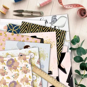Flat-Lay von floralem Scrapbook-Papier mit Bastelwerkzeugen auf hellem Holztisch