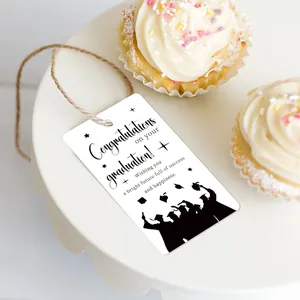 Detail of graduation gift tags with hemp rope and black silhouettes on a cake stand