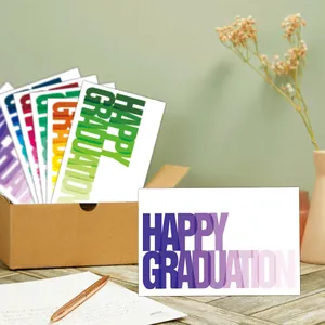 Set of 12 vibrant graduation cards with colorful gradient typography and a kraft gift box
