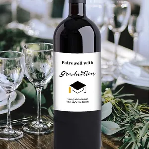 Detail of creative graduation bottle labels with elegant black text on a dark glass bottle