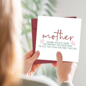 Close-up of hands holding a white Mother's Day greeting card with a dark red envelope