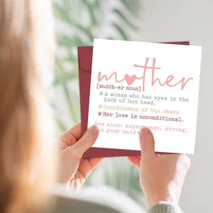 Person holding white Mother's Day card with deep red envelope and floral background