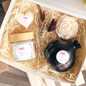 Pink Thank You stickers on a natural gift set with candles and dried floral arrangements