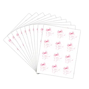 Detail of round pink ribbon thank you stickers stacked on white background