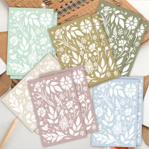 Close-up of six colorful floral note cards with white daisy patterns and craft envelopes