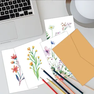 Detailed close-up of watercolor floral birthday cards with a yellow kraft envelope on a desk