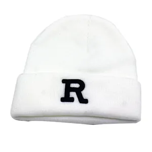 White knit beanie featuring black R letter embroidery and fine ribbed texture for winter
