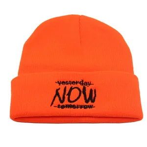 Detail of neon orange knit beanie featuring black letter embroidery with a cuffed design