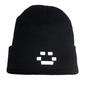 Détail du bonnet en maille noir avec broderie pixel smile blanche sur le revers