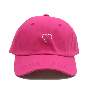 Détail de la broderie cœur sur casquette de baseball rose rouge avec visière courbée