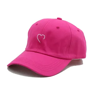 Détail d'une casquette de baseball rose rouge avec broderie cœur blanc et sergé de coton