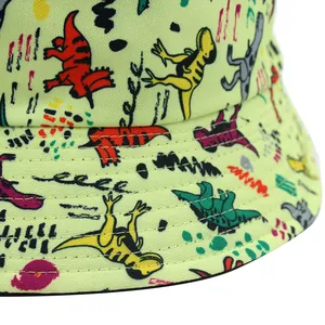 Light green bucket hat with colorful dinosaur prints and stitched twill fabric texture