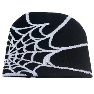 Detailed close-up of the knitted texture and spider web pattern on the black beanie