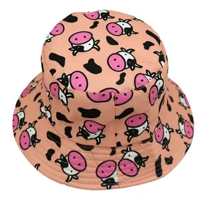 Pink reversible bucket hat with cartoon cow print and black spots for sun protection