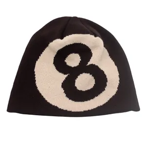 Gros plan sur la texture tricotée et la broderie boule 8 sur un bonnet noir tendance