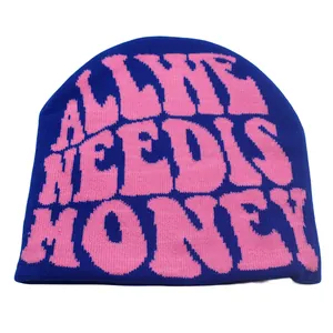 Detailaufnahme der dunkelblauen Strickmütze mit rosa All She Needs Is Money Aufschrift