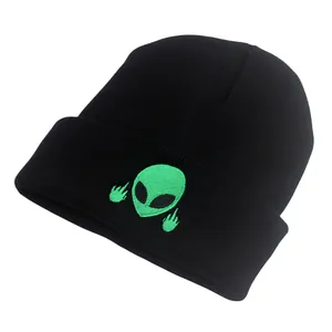 Bonnet noir avec broderie alien vert faisant un geste du majeur sur fond blanc neutre