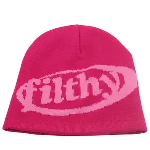 Macro-detail van de roze gebreide muts met filthy-belettering en fijne gebreide textuur