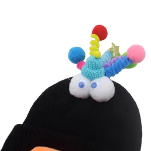 Funny black knit beanie with 3D monster eyes and colorful pom-poms for winter outdoor use