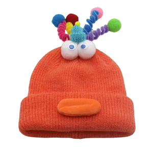 Funny orange monster knit beanie with colorful pom-poms and funny 3D eyeballs for winter