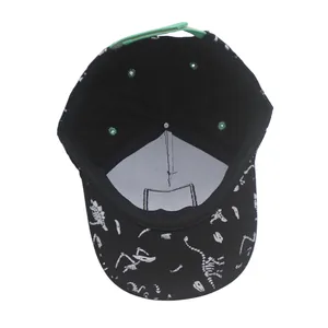 Detail view of cotton dinosaur baseball cap interior with adjustable green strap buckle