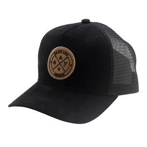 Classic black mesh trucker hat with a round brown leather patch showing a mountain logo