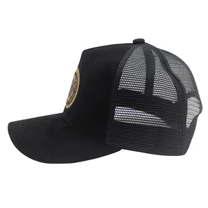 Detail of breathable mesh back and vintage round patch on black suede trucker hat