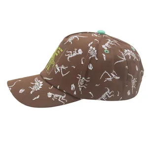 Detail of dinosaur print kids cotton baseball cap featuring green applique and brown fabric