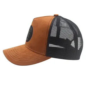 Side view of brown suede trucker hat with black mesh and circular embroidered logo patch