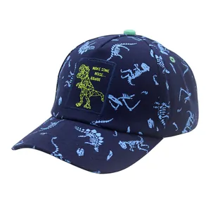 Close-up of navy cotton baseball cap with blue dinosaur skeleton print and green T-Rex patch