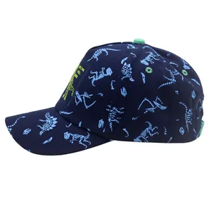 Detail view of navy blue kids baseball cap with dinosaur skeleton prints and green eyelets