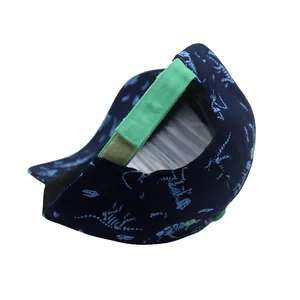 Detail of dinosaur print kids baseball cap showing green adjustable velcro strap closure