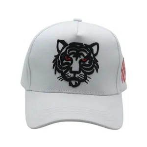 Detailed close-up of tiger head embroidery on a white cotton canvas baseball cap