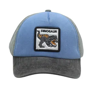 Detail of embroidered dinosaur patch on blue and grey kids' cotton baseball cap