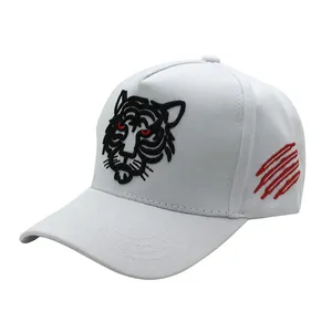 White cotton baseball cap with tiger head embroidery and red claw marks on a white background
